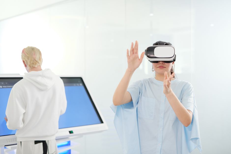 Woman exploring virtual reality with VR goggles in a modern technological environment.